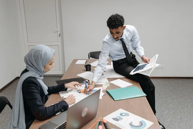 Colleagues discussing documents in a modern office meeting room. Reputation management selection checklist: scope, evidence, exit terms