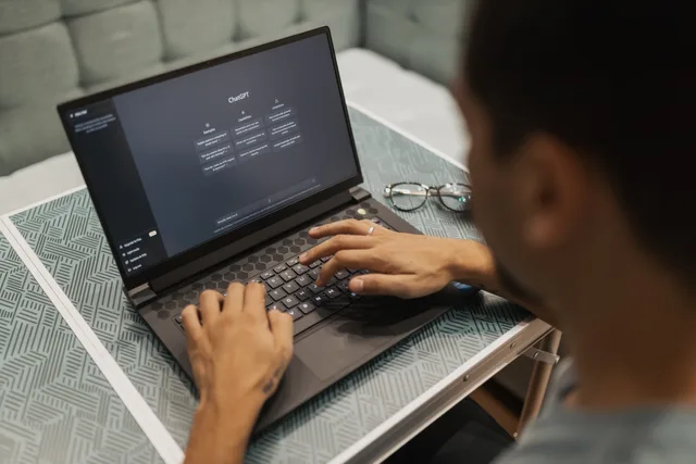 A person using a laptop to interact with AI technology indoors during the day. A reputation management strategy for disputed reviews